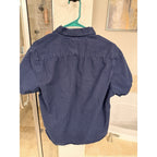 Second Half Supply Co, LLC navy blue short sleeve button-up shirt with white micro-dot pattern hanging on a hanger