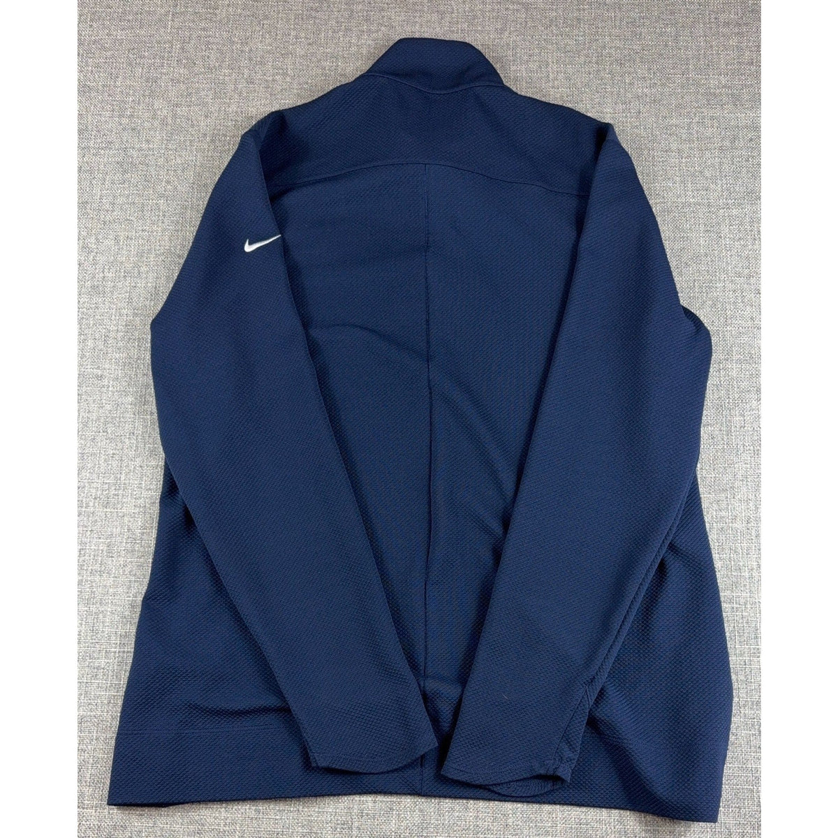 Second Half Supply Co, LLC navy blue Nike Dri-FIT golf pullover with white Swoosh logo on the sleeve, back view.
