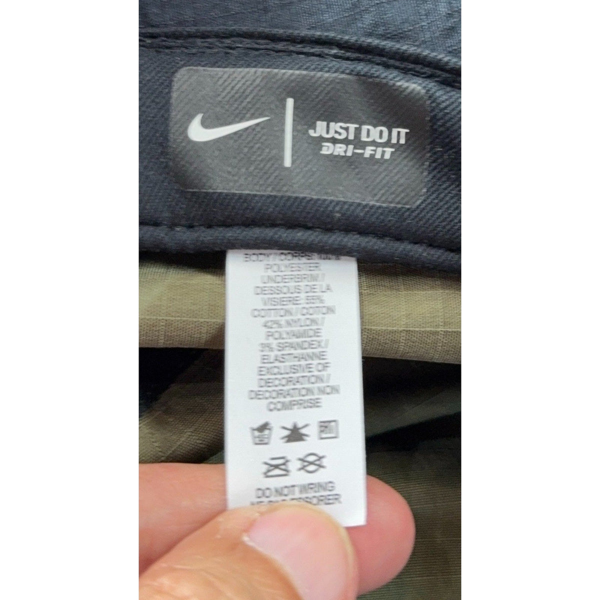 Second Half Supply Co, LLC Nike Dri-FIT hat care label showing material composition and washing instructions