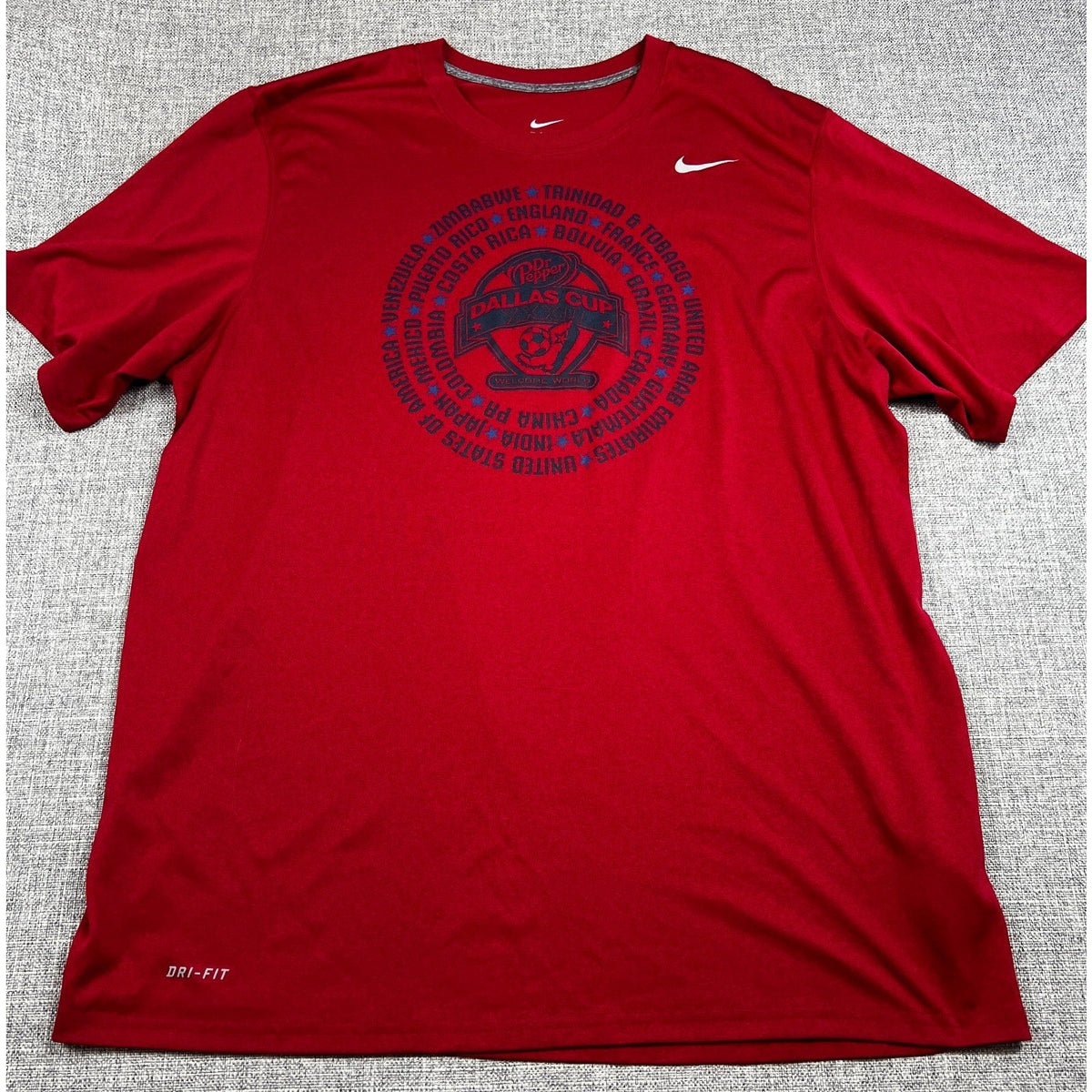 Second Half Supply Co, LLC red Nike Dri-FIT 2012 Dallas Cup soccer shirt with Welcome World graphic