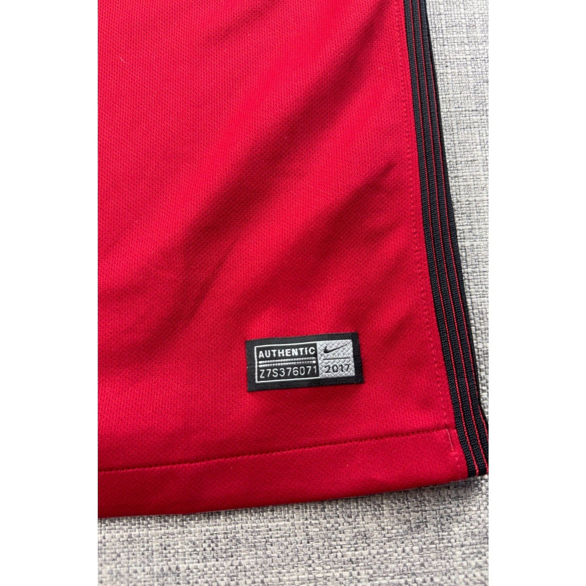 Second Half Supply Co, LLC red Nike USMNT soccer jersey featuring an authentic jock tag and side stripe detail.