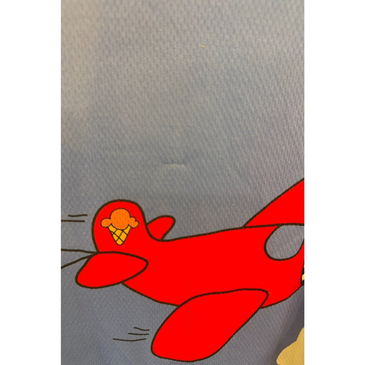 Second Half Supply Co, LLC vintage Pearl Izumi cycling jersey detail featuring a red airplane graphic on blue fabric