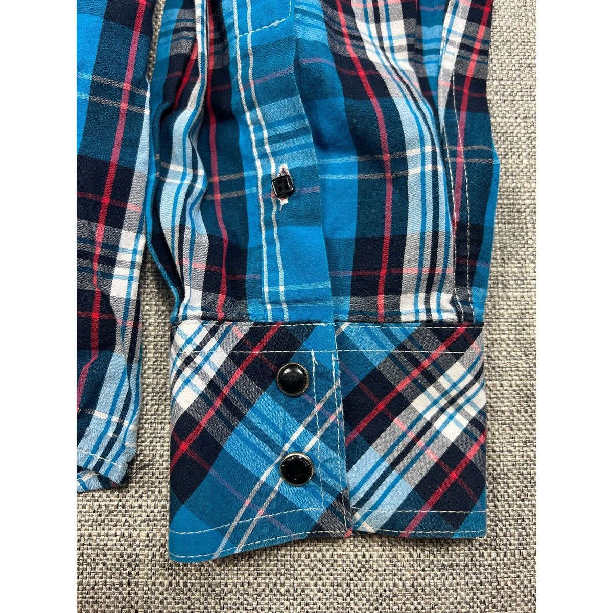 Second Half Supply Co, LLC blue plaid Western shirt cuff with black snap buttons and contrast paisley lining