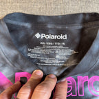Second Half Supply Co, LLC Polaroid shirt interior neck label showing size XXL and 100% cotton material details