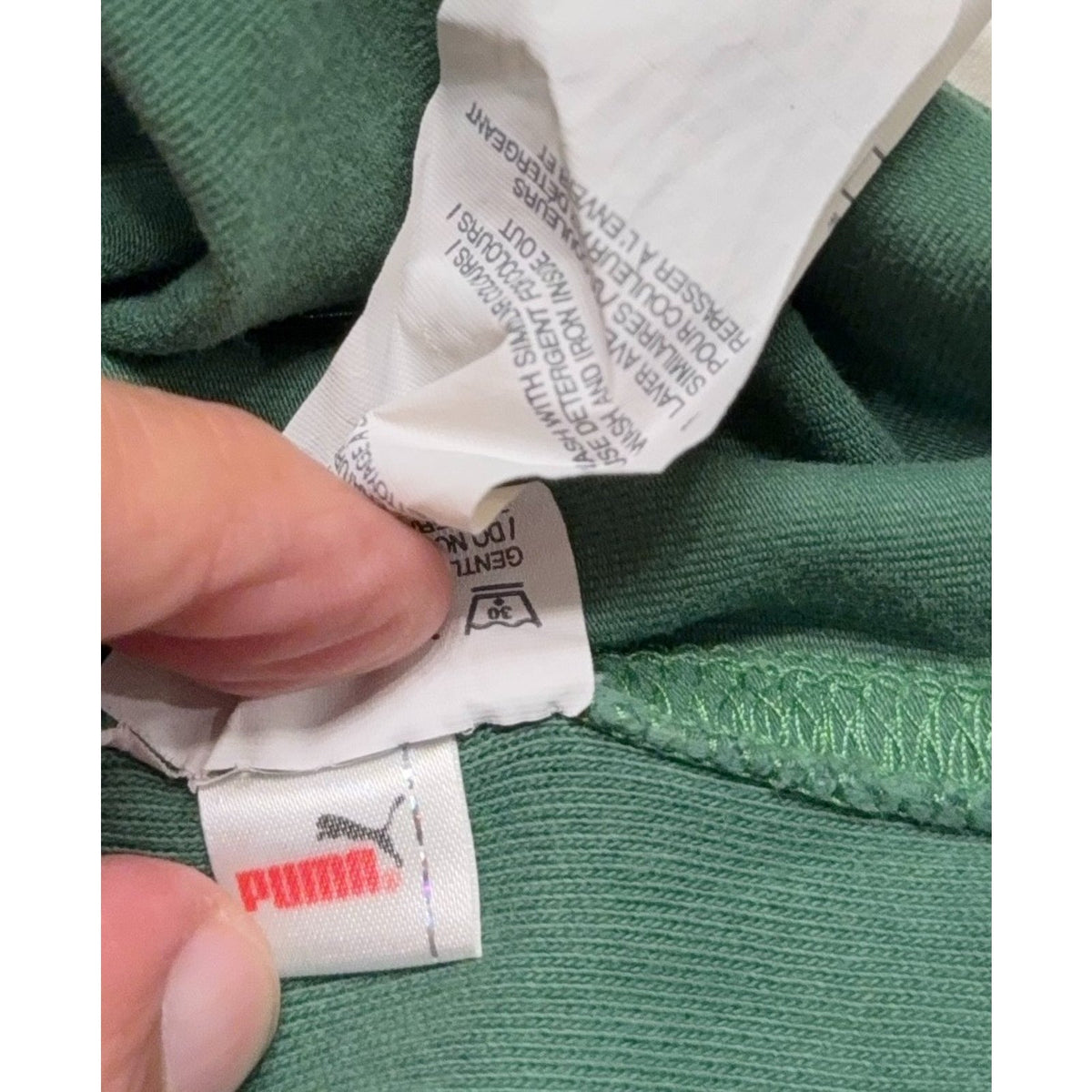 Second Half Supply Co, LLC Puma rugby shirt interior care label and branding on green cotton fabric