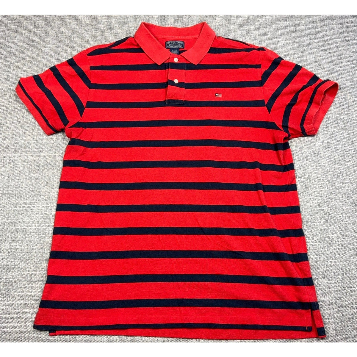 Second Half Supply Co, LLC red and navy striped cotton polo shirt with embroidered flag logo and two-button placket.
