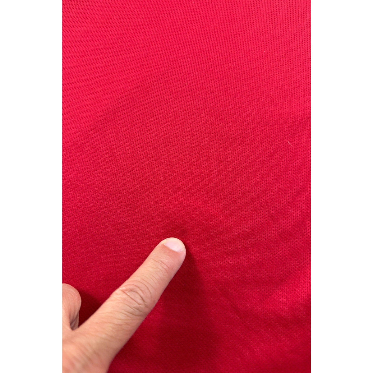 Second Half Supply Co, LLC red Nike Dri-FIT soccer jersey fabric showing a small spot of wear
