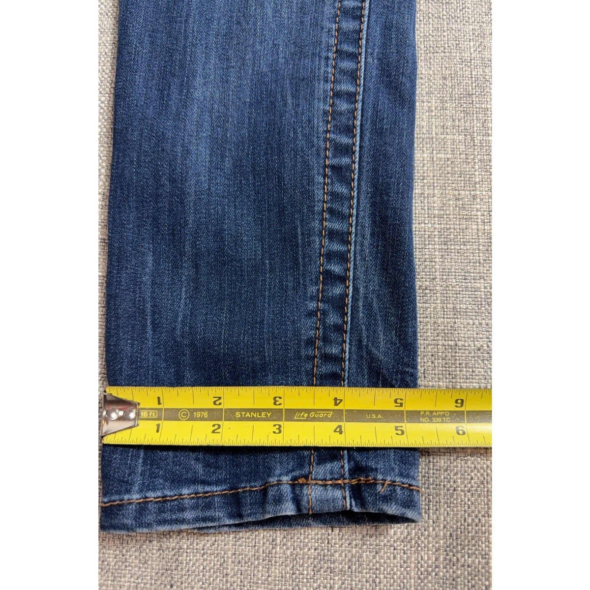 Second Half Supply Co, LLC Seven7 medium blue stretch denim skinny jeans leg opening measurement with yellow tape