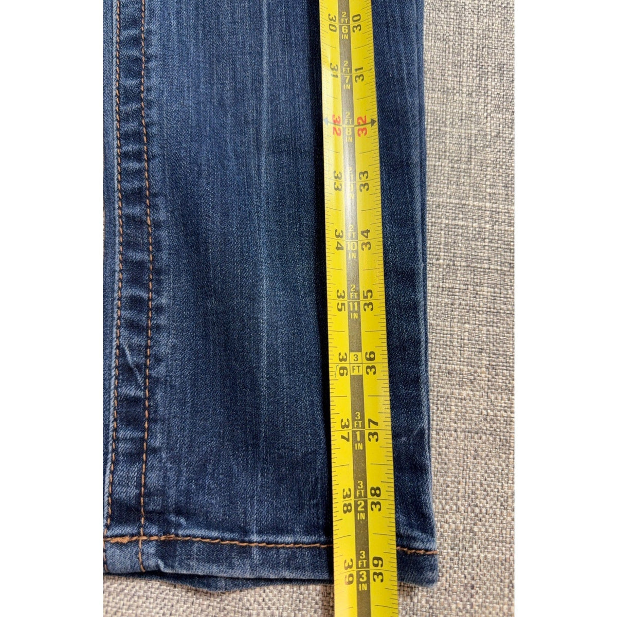 Second Half Supply Co, LLC Seven7 high-rise skinny jeans showing a 39-inch total length measurement on a yellow tape.