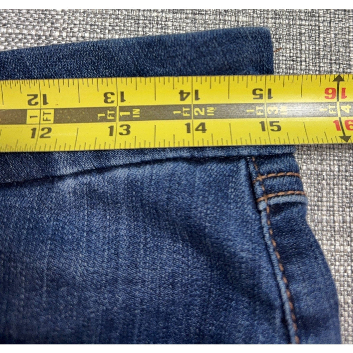 Second Half Supply Co, LLC Seven7 high-rise skinny jeans waist measurement showing 15.5 inches on a yellow tape measure