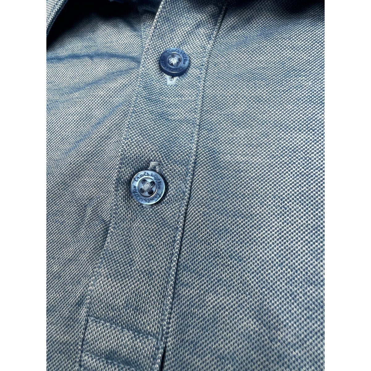 Second Half Supply Co, LLC heathered blue TravisMathew polo shirt with branded buttons and textured fabric detail