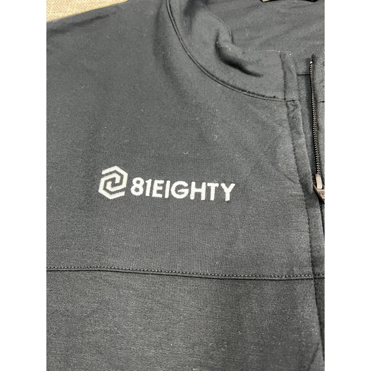Second Half Supply Co, LLC TravisMathew black fleece jacket featuring an embroidered 81Eighty logo on the chest