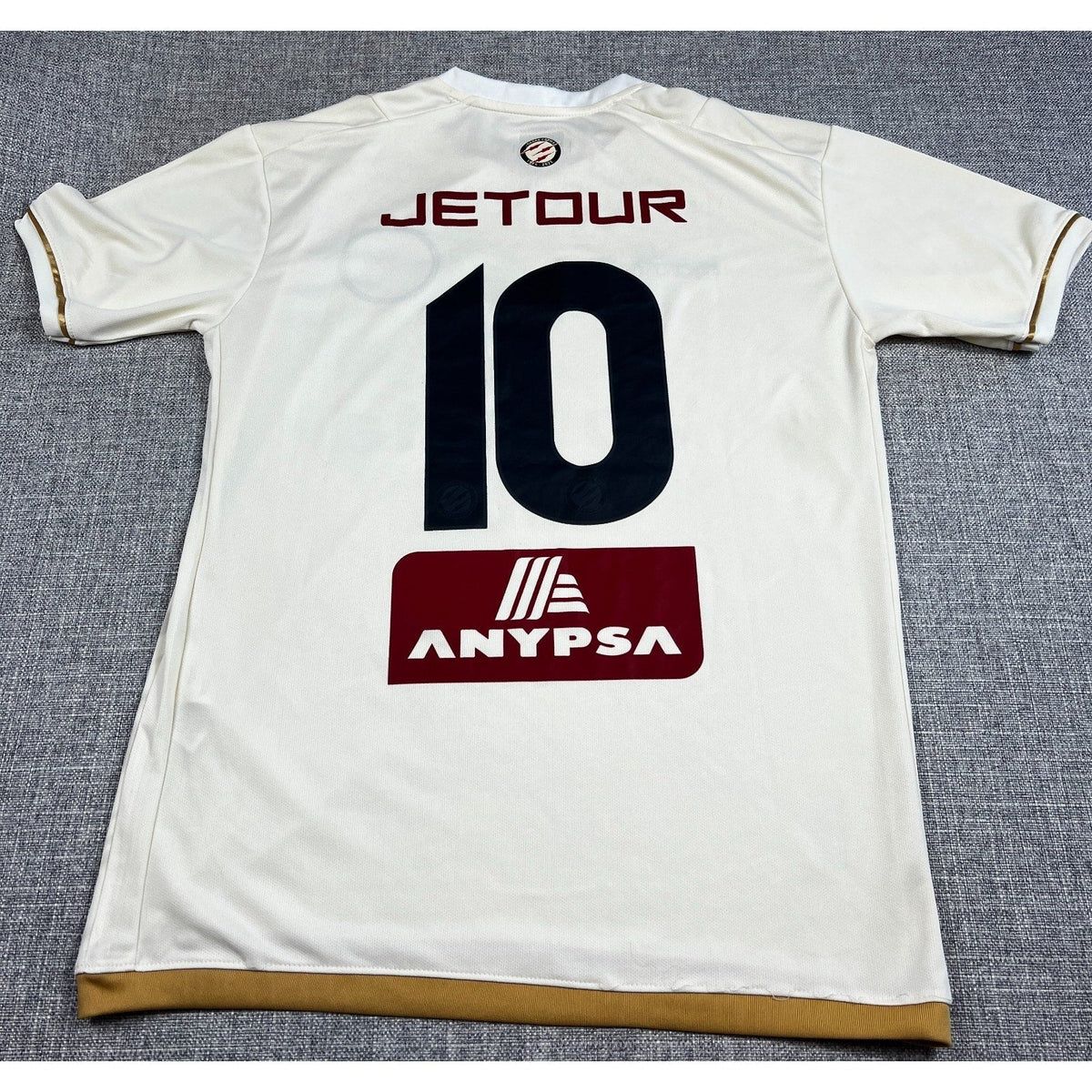 Back of Second Half Supply Co, LLC Universitario 2025 home jersey in cream with number 10 and sponsor graphics.