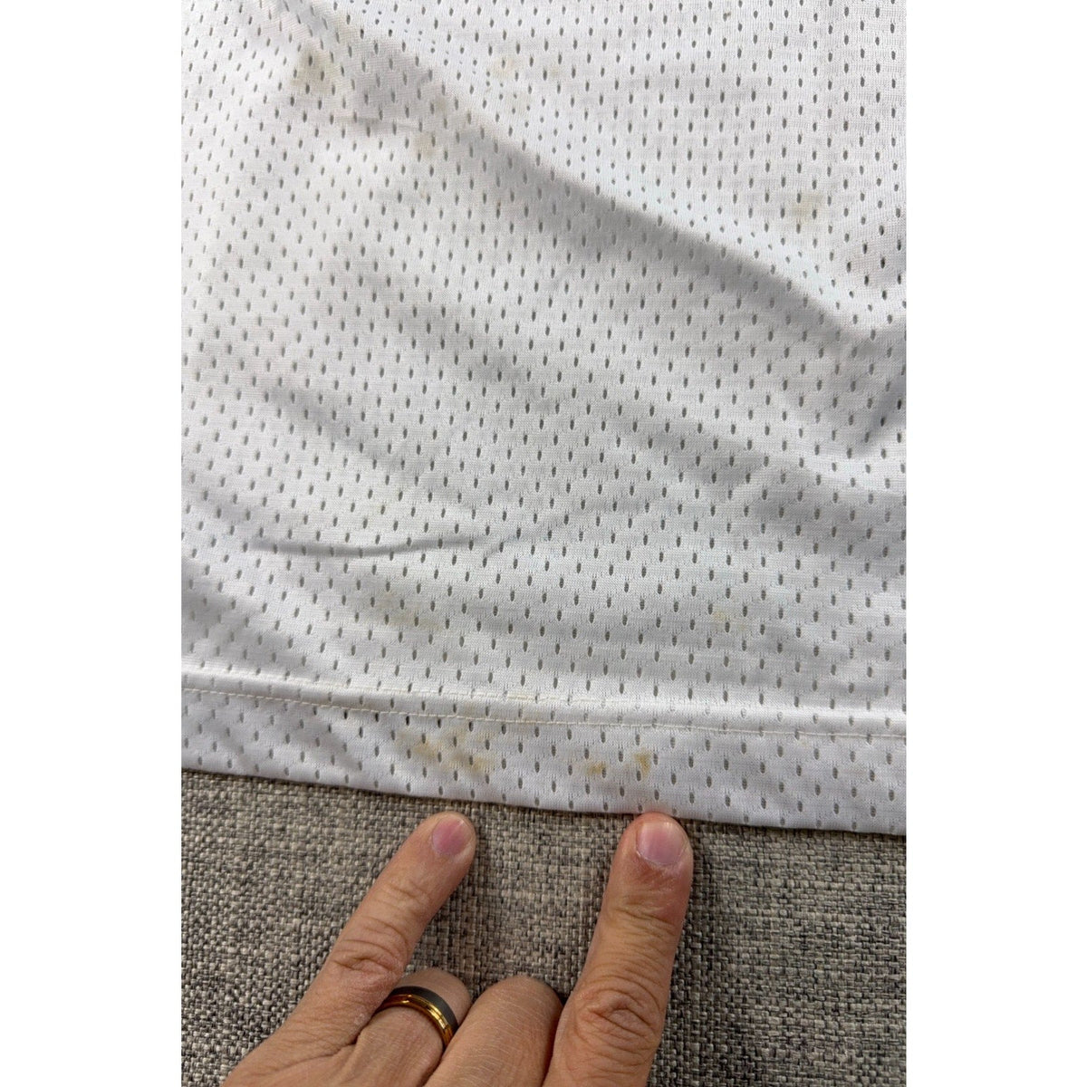 Second Half Supply Co, LLC vintage white mesh football jersey showing small stains near the bottom hem