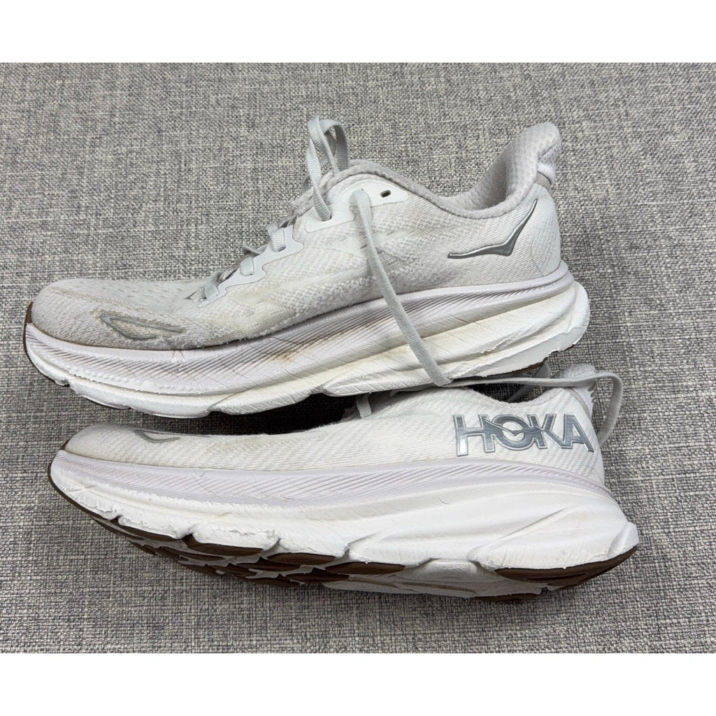 Second Half Supply Co, LLC pre-owned white HOKA Clifton 9 women's running shoes with visible wear and discoloration.