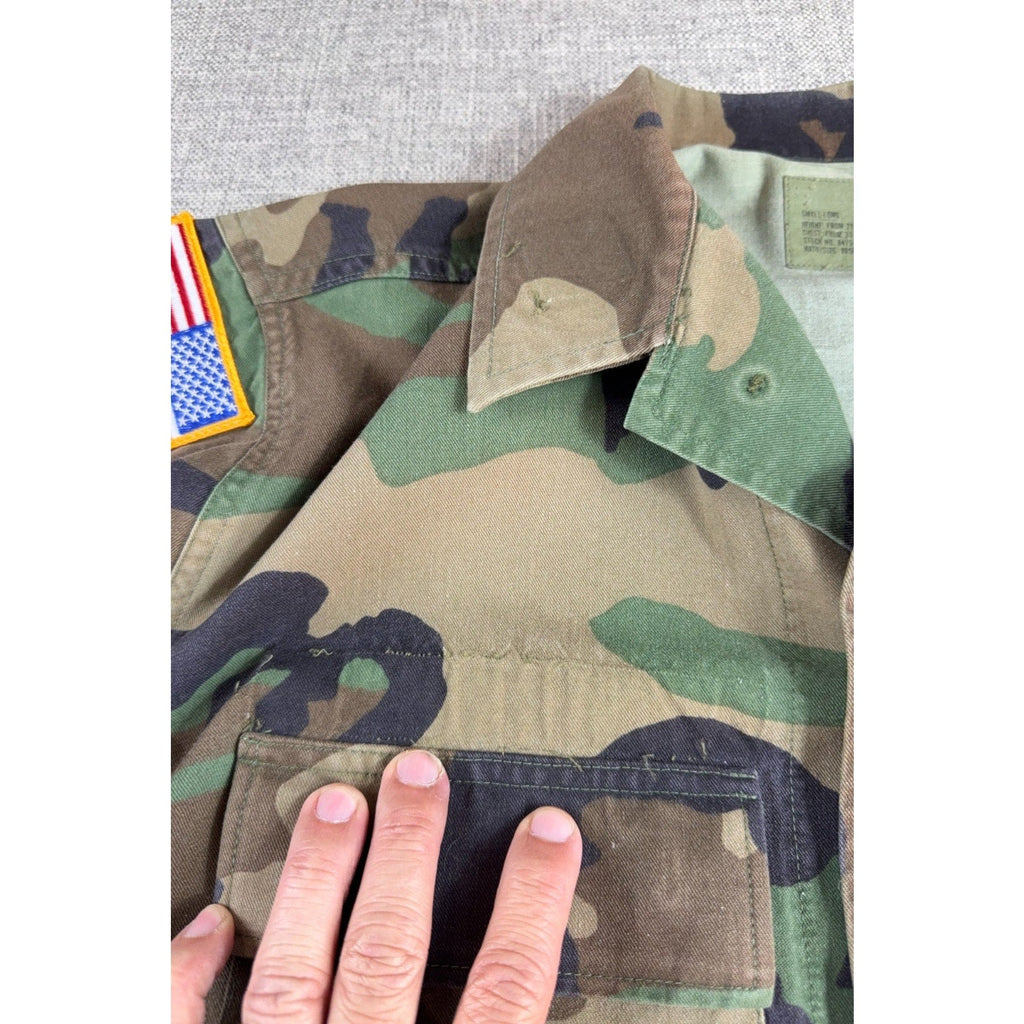 Second Half Supply Co, LLC vintage 1993 M81 Woodland camo BDU combat coat with US flag patch on shoulder